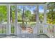 Covered front porch with white columns and railings, offering a pleasant view of the landscaped yard at 2076 Rookery Ln, Charleston, SC 29414