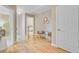 Bright hallway area with gleaming hardwood floors, decorative bench, and doorway to a bedroom at 2076 Rookery Ln, Charleston, SC 29414