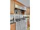 Stainless steel gas range and hood with wood cabinets and black countertops at 2076 Rookery Ln, Charleston, SC 29414