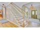 Inviting foyer featuring a classic staircase with white spindles and light wood treads and hardwood floors at 2076 Rookery Ln, Charleston, SC 29414