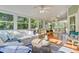 Light-filled sunroom with hardwood floors and multiple seating areas at 2076 Rookery Ln, Charleston, SC 29414