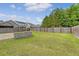 A large backyard with a stone patio, a firepit, and wood fencing offers privacy and space for outdoor activities at 212 Palmetto Walk Dr, Summerville, SC 29486