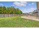 A fenced backyard features a manicured lawn, brick patio, and stone firepit for outdoor enjoyment at 212 Palmetto Walk Dr, Summerville, SC 29486