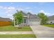 Attractive gray home with a well-maintained lawn, showcasing a spacious driveway and a charming covered porch at 212 Palmetto Walk Dr, Summerville, SC 29486