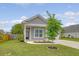 Beautifully landscaped front yard with a well-maintained lawn and a charming gray home with a covered porch at 212 Palmetto Walk Dr, Summerville, SC 29486