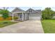 Charming gray home featuring a well-manicured lawn and a spacious driveway leading to an attached two-car garage at 212 Palmetto Walk Dr, Summerville, SC 29486