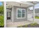 Inviting covered porch featuring stylish columns, a classic entry door, and a view of the attached two-car garage at 212 Palmetto Walk Dr, Summerville, SC 29486