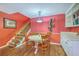 Cozy dining area boasts hardwood floors, red accent wall with wine rack, and a staircase leading to the upper level at 2120 Fife Ln, Charleston, SC 29414