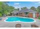 A large kidney-shaped pool is nestled in a beautifully landscaped backyard, complete with patio, outdoor seating and lush greenery at 2120 Fife Ln, Charleston, SC 29414