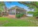 Screened porch with brick facade offers a cozy outdoor seating area, providing privacy and a connection to the lush surroundings at 2120 Fife Ln, Charleston, SC 29414