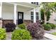 Close up shot of the front entry featuring stone accents, a black door, and manicured landscaping at 218 Austin Creek Ct, Summerville, SC 29483