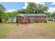 Backyard view featuring a small wooden deck, a brick exterior, and a well-maintained lawn at 2220 Pinehurst Ave, Charleston, SC 29414