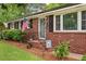 Charming brick home featuring an inviting front porch, an American flag, and a beautifully landscaped yard at 2220 Pinehurst Ave, Charleston, SC 29414