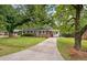 Charming brick home with a well-maintained lawn, mature trees, and a welcoming front porch, offering curb appeal at 2220 Pinehurst Ave, Charleston, SC 29414