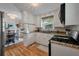Well-lit kitchen with white cabinets, granite countertops, and modern appliances, seamlessly connected to the dining area at 2220 Pinehurst Ave, Charleston, SC 29414
