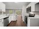 Updated kitchen boasts stainless steel appliances, granite counters, and white cabinetry at 240 Eagle Ridge Rd, Summerville, SC 29485