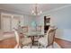Elegant dining room featuring a glass table, chandelier, and views of the outdoors through window at 25 Fitzroy Dr, Charleston, SC 29414