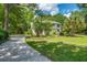 Spacious driveway leading to a well-maintained home with lush greenery, showcasing privacy and a welcoming entrance at 25 Fitzroy Dr, Charleston, SC 29414