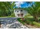 Spacious two-car garage with a paved driveway surrounded by lush greenery and mature trees at 25 Fitzroy Dr, Charleston, SC 29414