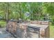Outdoor kitchen features a stone counter, built-in grill, sink, and refrigerator for outdoor cooking and entertaining at 25 Fitzroy Dr, Charleston, SC 29414