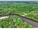 Aerial view of a house with waterfront access surrounded by lush green forest at 263 Gator Walk, Ridgeville, SC 29472