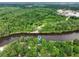 An aerial view of a riverfront home surrounded by lush greenery and a serene waterway at 263 Gator Walk, Ridgeville, SC 29472