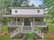 Charming two-story home with a large porch, wooden stairs, and mature landscaping at 263 Gator Walk, Ridgeville, SC 29472