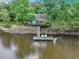 Scenic view of a waterfront home with a dock featuring chairs, offering a serene retreat at 263 Gator Walk, Ridgeville, SC 29472