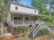 Charming two-story home with a large porch, wooden stairs, and mature landscaping at 263 Gator Walk, Ridgeville, SC 29472