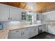 Bright kitchen featuring white shaker cabinets, herringbone backsplash, and a farmhouse sink at 263 Gator Walk, Ridgeville, SC 29472