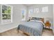 Cozy bedroom features large windows, wood flooring, and a comfortable bed with decorative pillows at 2844 Pinelog Ln, Johns Island, SC 29455