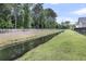 View of the drainage canal, bordered by green lawns, located near the property at 2844 Pinelog Ln, Johns Island, SC 29455