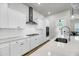 Bright kitchen features stainless appliances, white cabinets, stone countertops, and hardwood flooring at 2844 Pinelog Ln, Johns Island, SC 29455