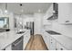 Modern kitchen with stainless appliances, white cabinetry, stone countertops, an island, and hardwood flooring at 2844 Pinelog Ln, Johns Island, SC 29455