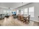 Open-concept living room with hardwood floors adjacent to a dining area and abundant natural light at 2844 Pinelog Ln, Johns Island, SC 29455