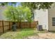 Fenced backyard with green grass, a mature tree, a trash can and an air conditioning unit at 300 Greens Ct, Goose Creek, SC 29445