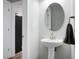 Bathroom with a pedestal sink, oval mirror, and modern fixtures at 300 Greens Ct, Goose Creek, SC 29445