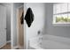 Bright bathroom with a white tub, tile shower, and neutral wall color and a towel hanging on the wall at 300 Greens Ct, Goose Creek, SC 29445