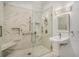 Modern bathroom showcasing marble tile shower with frameless glass and a pedestal sink with custom fixture at 3002 Edenvale Rd, Johns Island, SC 29455