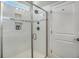 A modern shower featuring white tile, with built in shampoo/soap containers. A glass door encloses the shower at 3002 Edenvale Rd, Johns Island, SC 29455
