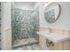 Bathroom featuring a tile shower with glass door and a custom sink with circular mirror at 3002 Edenvale Rd, Johns Island, SC 29455