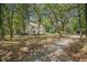 View of the rear exterior of a white two-story home surrounded by mature trees on a sprawling lot at 3002 Edenvale Rd, Johns Island, SC 29455