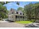 Inviting two-story home with a wrap-around porch, accessible ramp, and lush greenery at 3002 Edenvale Rd, Johns Island, SC 29455