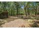 A wood storage shed sits in a wooded area with mature trees surrounding a cleared fire pit area at 3002 Edenvale Rd, Johns Island, SC 29455