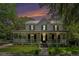 Beautiful two-story home at twilight featuring a welcoming porch with inviting outdoor seating at 3002 Edenvale Rd, Johns Island, SC 29455