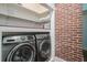 Well organized laundry room featuring a front-load washer and dryer, plus an exposed brick wall at 3002 Edenvale Rd, Johns Island, SC 29455