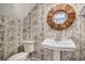 Charming powder room with designer wallpaper, pedestal sink, and decorative mirror at 3002 Edenvale Rd, Johns Island, SC 29455