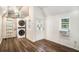 Bright room with stacked washer and dryer, wood-look flooring, and a white door at 3002 Edenvale Rd, Johns Island, SC 29455