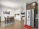 Open dining room with hardwood floors, area rug, modern chandelier, and stainless steel refrigerator at 312 Silverdrop St, Goose Creek, SC 29445