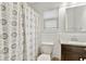 Well-lit bathroom with a shower curtain, window, vanity, and wood-look cabinet at 313 Janice St, Goose Creek, SC 29445